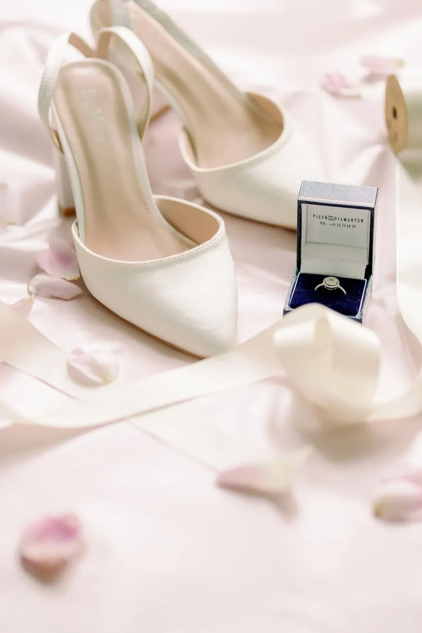 Bridal shoes, a ring in its box and petals laid out on pale satin