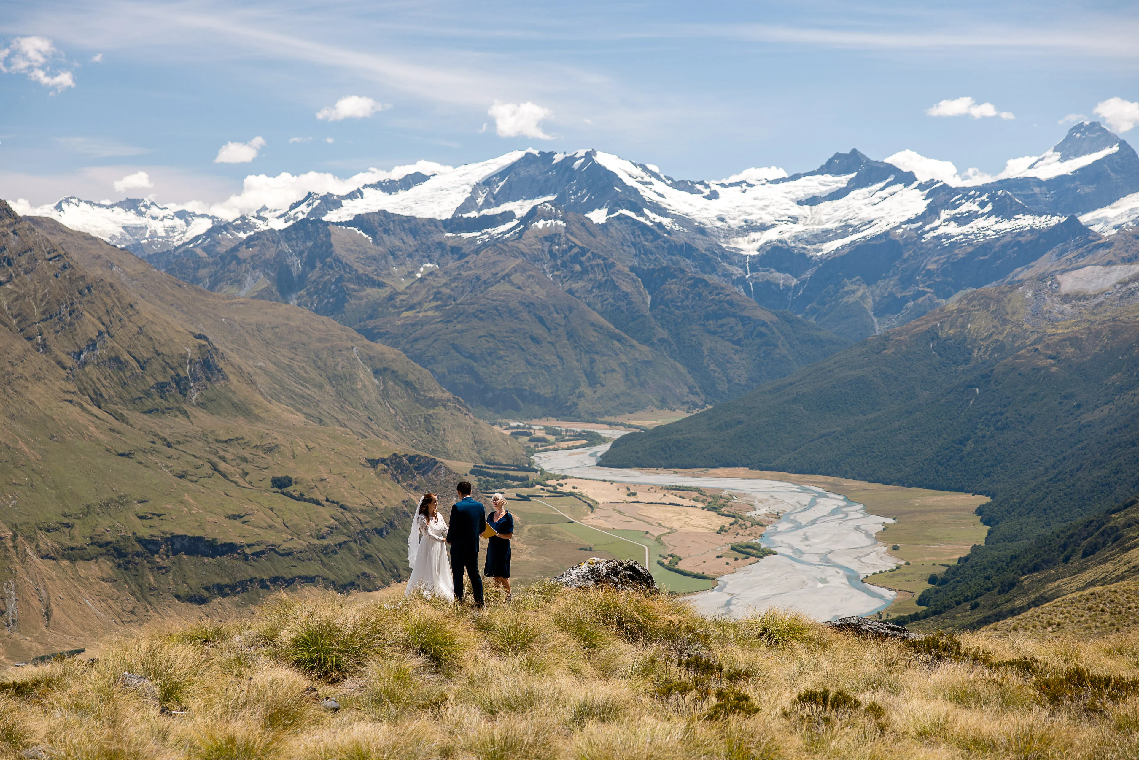 A couple exchanging vows with their celebrant at Alta Tarns, overlooking the Matukituki Valley and the Southern Alps