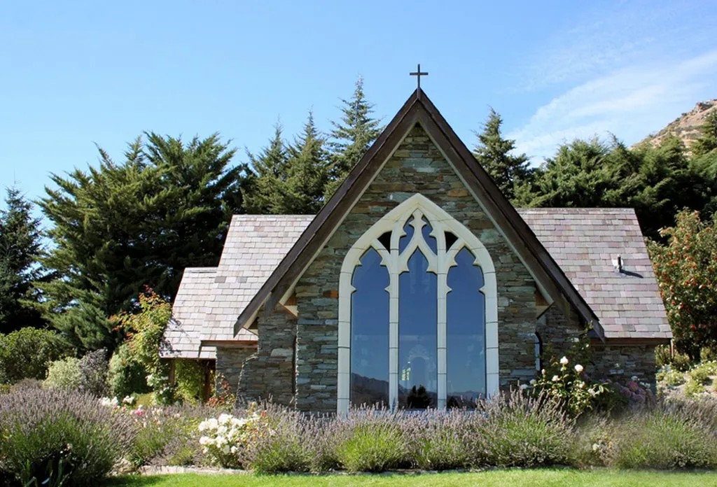 The stone Chapel by the Lake at Stoneridge Estate, framed by established gardens near Queenstown