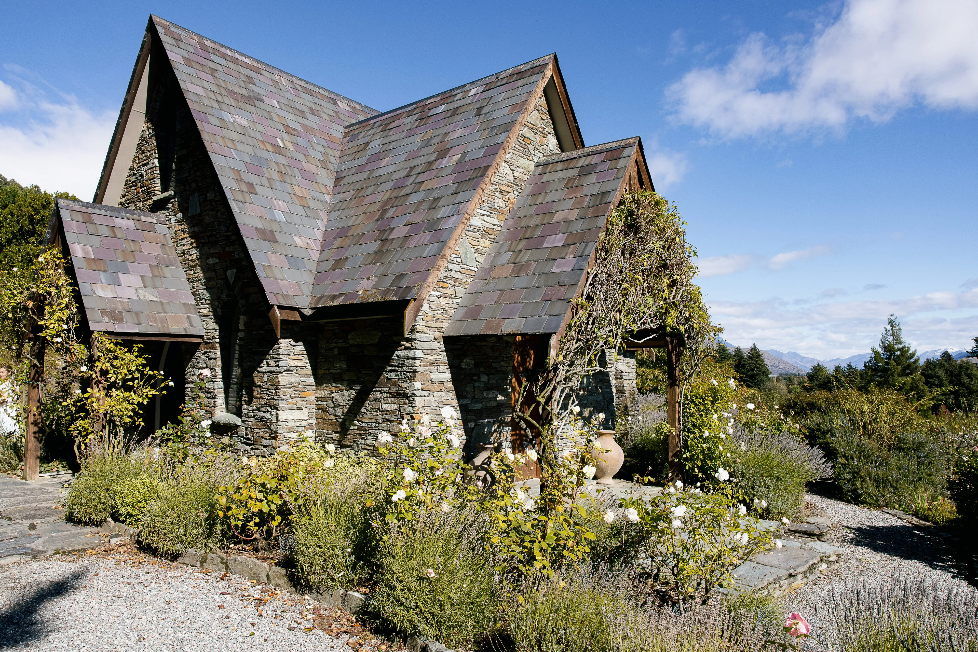 The stone Chapel by the Lake set among lavender and rose gardens with mountain views