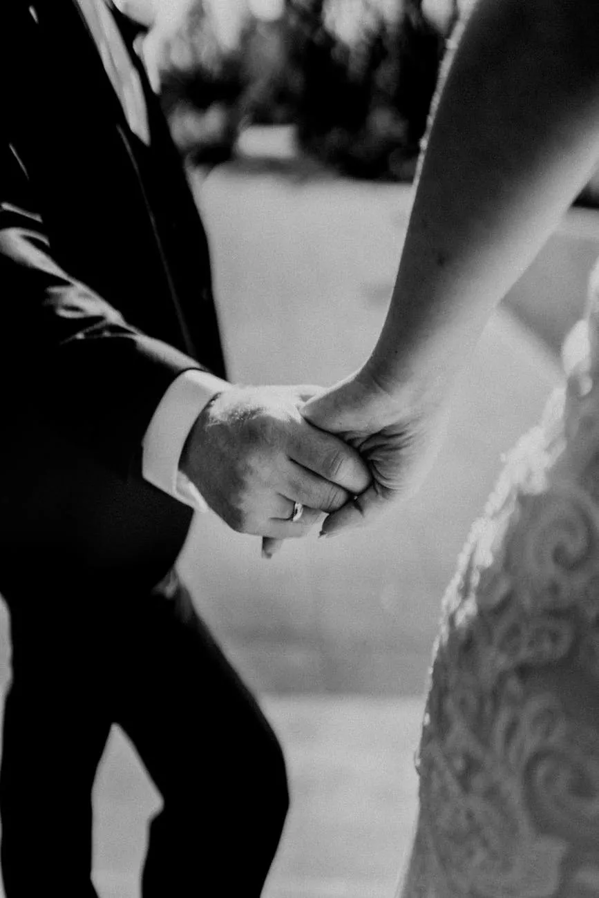 Bride and groom holding hands, close-up in black and white