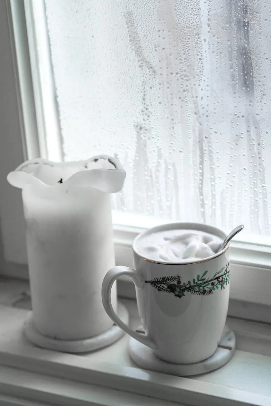 Mug of hot chocolate and a candle on a windowsill with rain on the glass