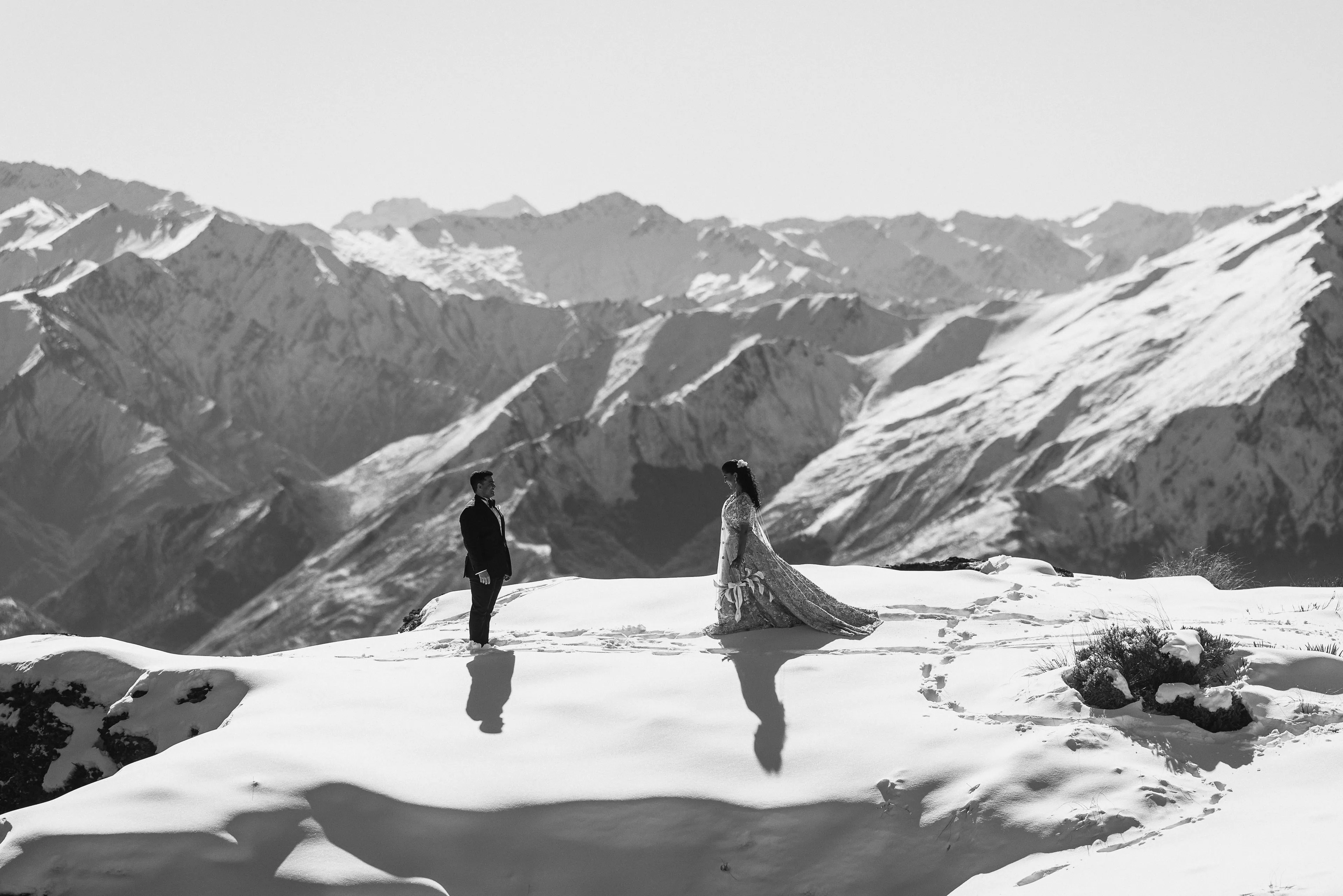 A black-and-white portrait of a couple on the snowy Ledge at Cecil Peak