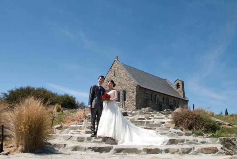 Bride and Groom standing on the stone steps at the Church of the Good Shepherd, Lake Tekapo
