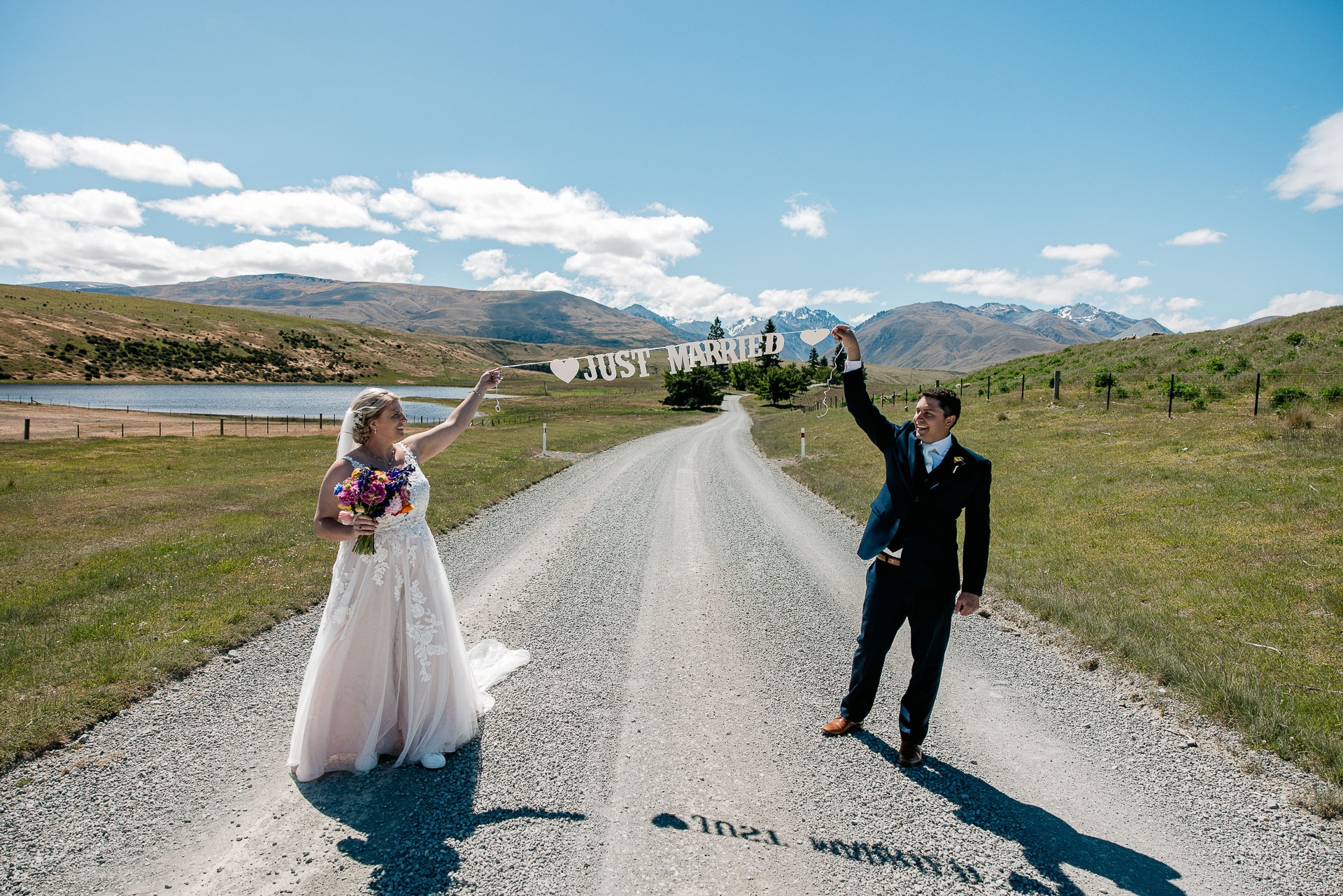 Couple running together after their New Zealand elopement on a scenic rural road