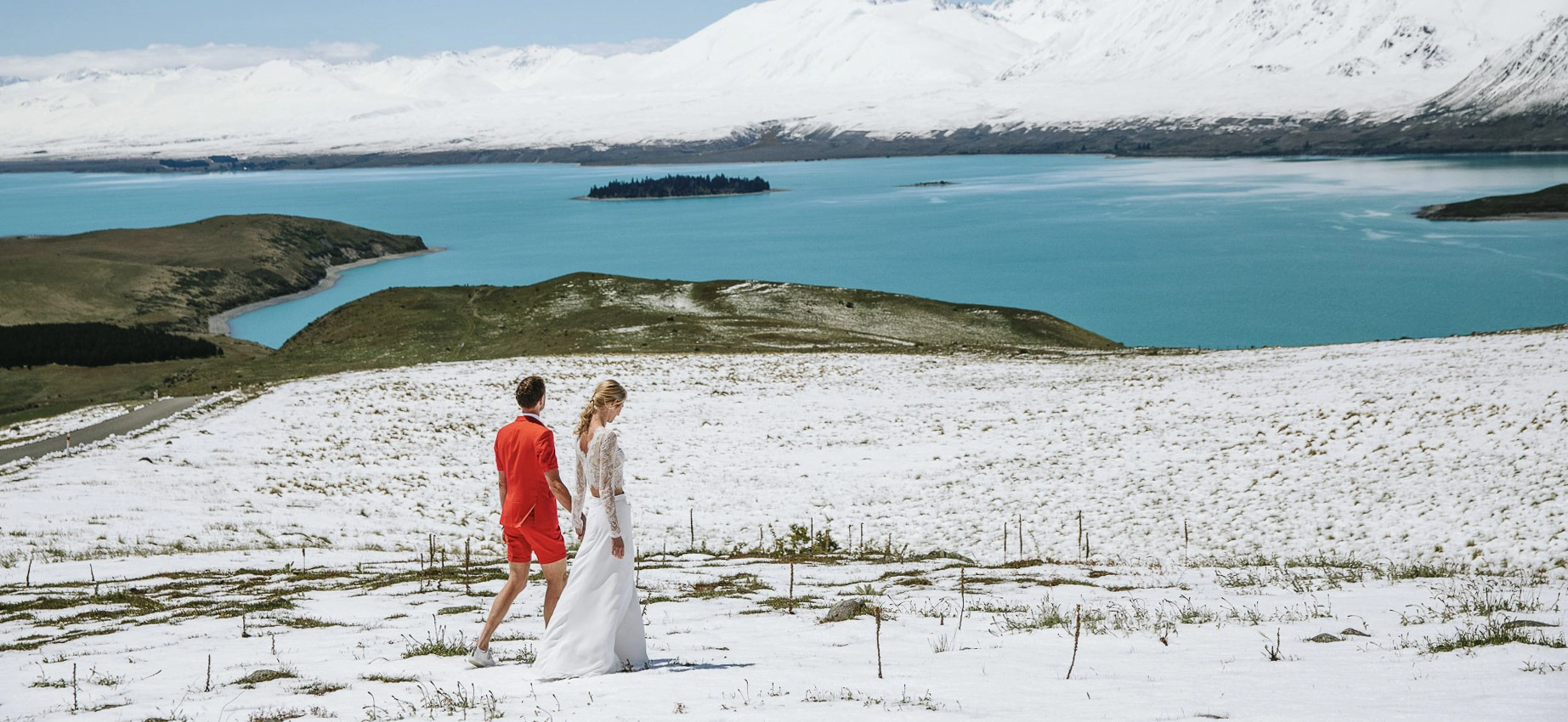 A couple walking on a snow covered mountain near Lake Tekapo during their New Zealand Dream Weddings elopment.