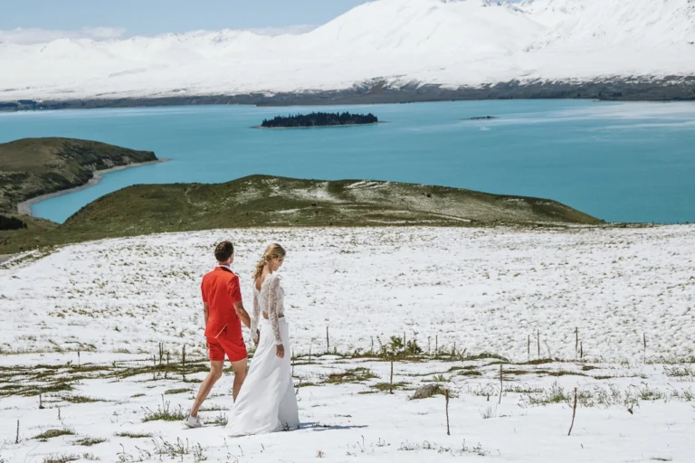 A couple walking on a snow covered mountain near Lake Tekapo during their New Zealand Dream Weddings elopment.